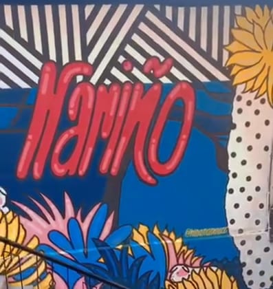 Mural de la escalera de Xantico: la palabra Nariño pintada en rojo sobre azul cobalto, con franjas blancas y negras y flores de colores.